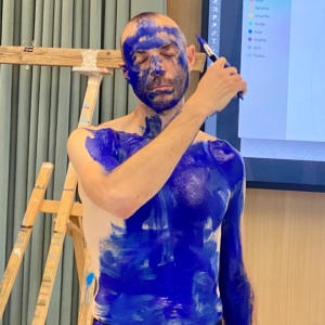 Artista haciendo una performance en directo pintando su cuerpo